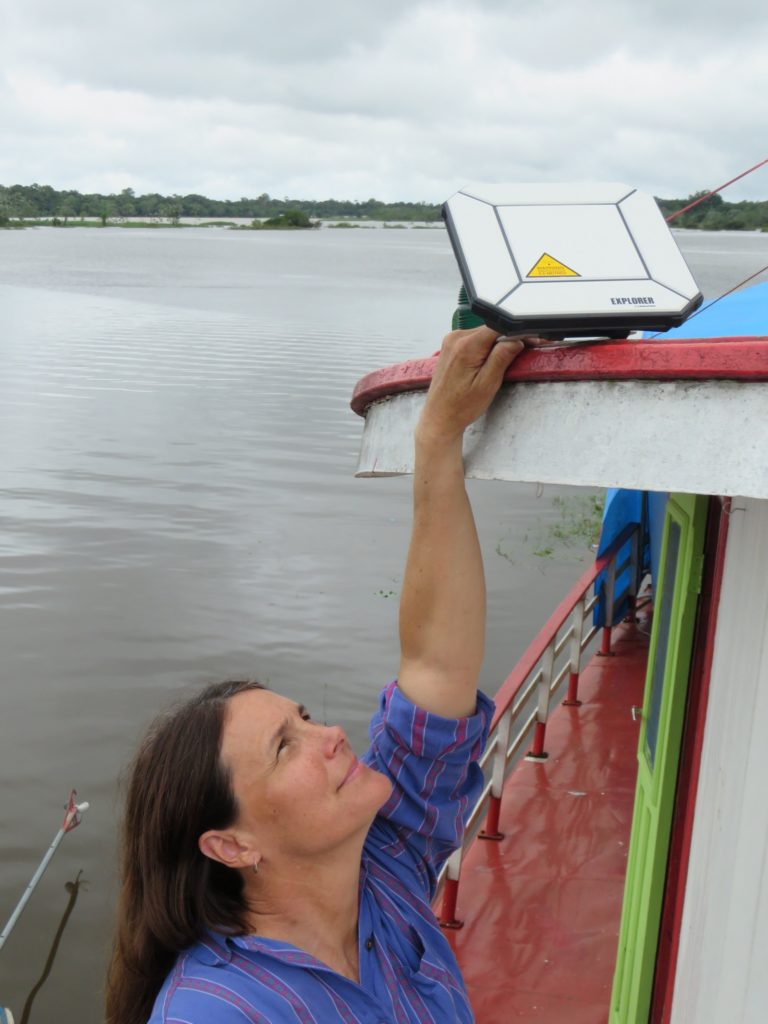Laura adjusts the signal for the satellite hub so that Houseboat Amazon can send photos and email. (Photo courtesy of Laura K. Marsh)