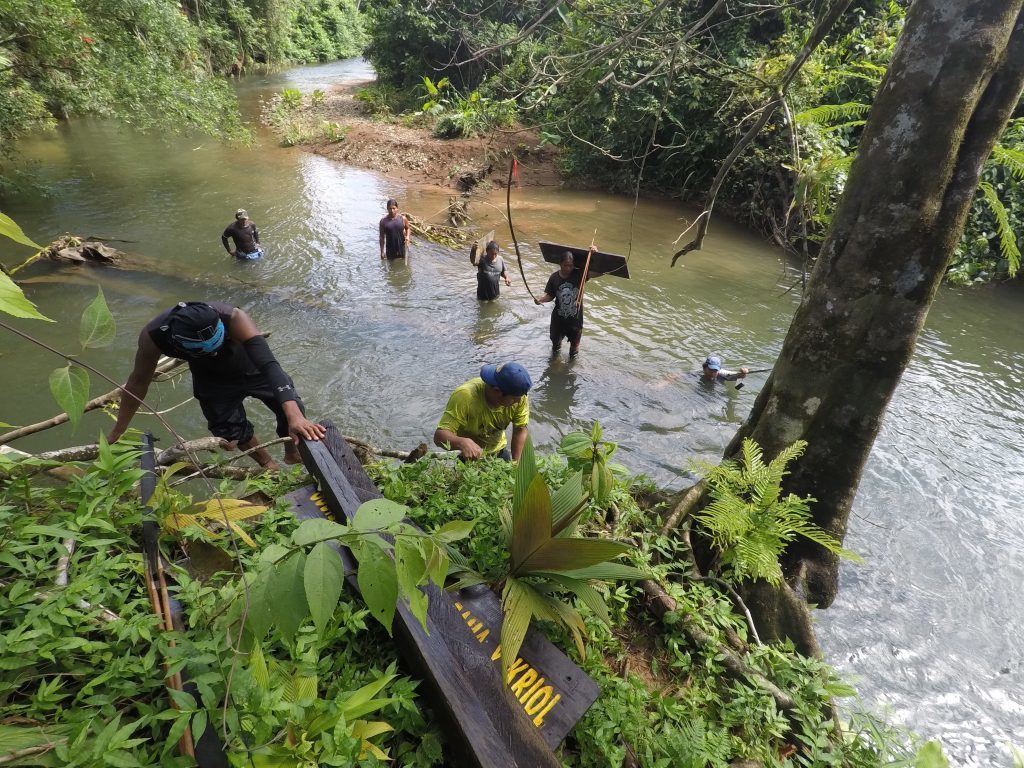 Rama community members carrying a sign into the forest for installation after the hurricane. (Photo by Yoharlyn Martinez)