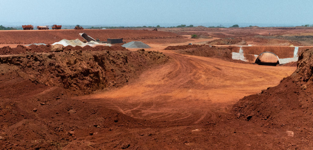 A bauxite mine that has completely destroyed the forest that once stood in the same spot. Now, only red soil remains.